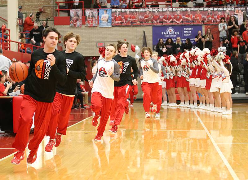 Members of the Ottawa boys basketball team take the floor in Kingman Gymnasium on Friday, Feb. 10, 2023 at Ottawa High School.