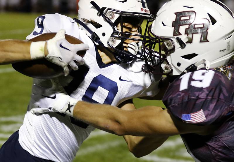 Cary-Grove's Andrew Prio is tackled by Prairie Ridge's Jeffrey North during a Fox Valley Conference football game between Prairie Ridge  and Cary-Grove Friday, Sept. 23, 2022, at Prairie Ridge High School in Crystal Lake.