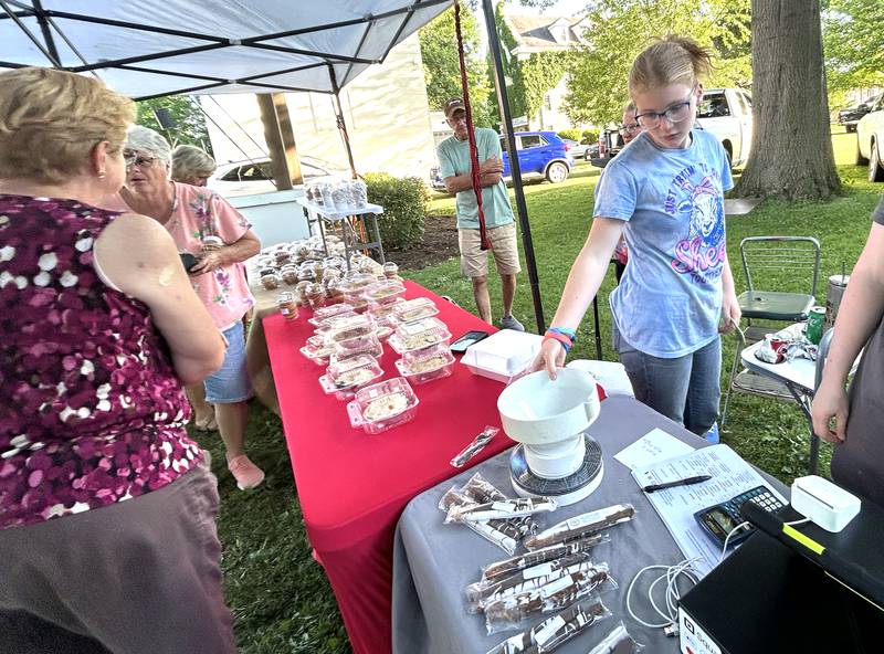 Keandria Marceau sets the scale to weigh green beans at the Ewe and Me Acres booth at the farmers market at the Mt Morris Jamboree on Friday, June 27, 2025.