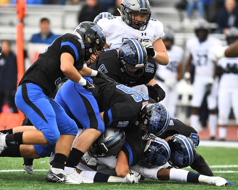 Lincoln-Way East's defense gang tackles Oswego East's quarterback Robert Tyre Jones III (9) on Saturday, Oct. 30, 2021, at Lincoln-Way East High School in Frankfort.