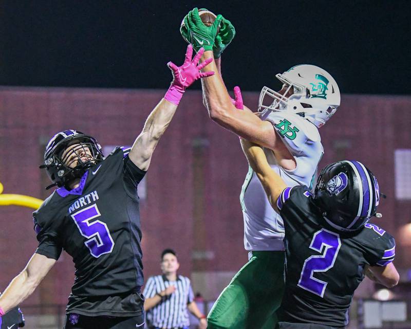 York's Hunter Stephinach (87) catches a pass in the endzone for a touchdown during the game on Friday Oct. 10, 2025, while being defended by Downers Grove North teammates Max Troha (5) and Shawn Toth (2) held at Downers Grove North High School.