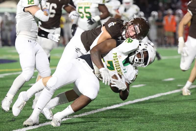 Joliet Catholic’s Griffin Alessio stops Providence Jamari Tribett for a loss on Friday, Sept. 1, 2023 Joliet Memorial Stadium.