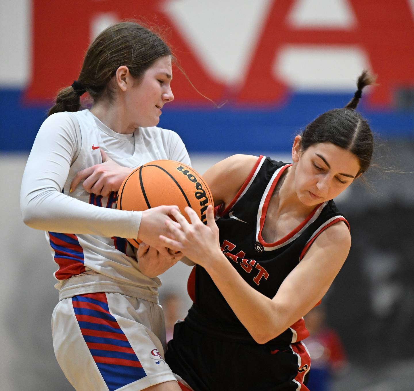 Glenbard South's Jordan Bailey, left, ties up the ball as she defends against Glenbard East's Haley Greenfield during Friday’s game in Glen Ellyn.