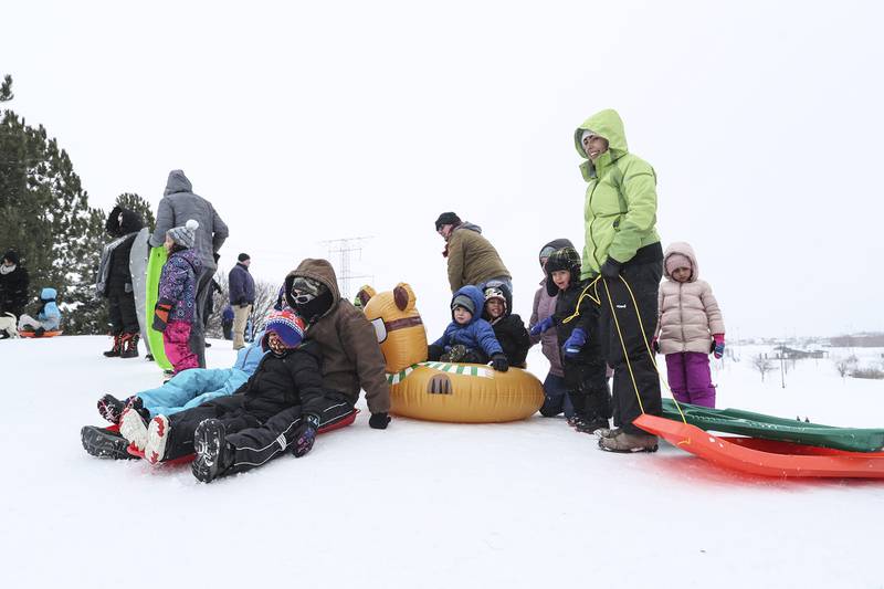 Sledders prepare for their turn down the hill on Sunday, Jan. 31, 2021, at Cene's Four Seasons Park in Shorewood, Ill. Nearly a foot of snow covered Will County overnight, resulting in fun for some and challenges for others.