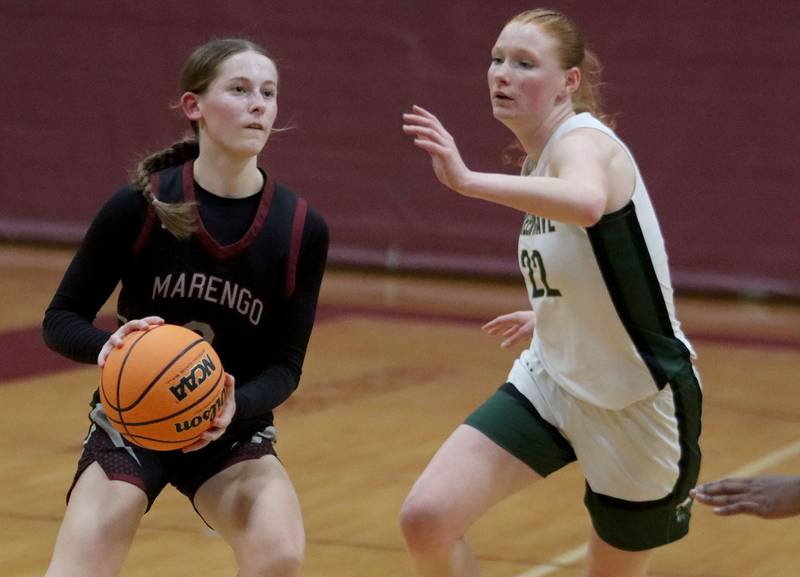 Marengo’s Maggie Hanson, left, looks for an option as St. Edwards’ Layne Dawson closes in  in IHSA Regional Championship girls basketball on Thursday, Feb. 19, 2026, at Marengo High School in Marengo.