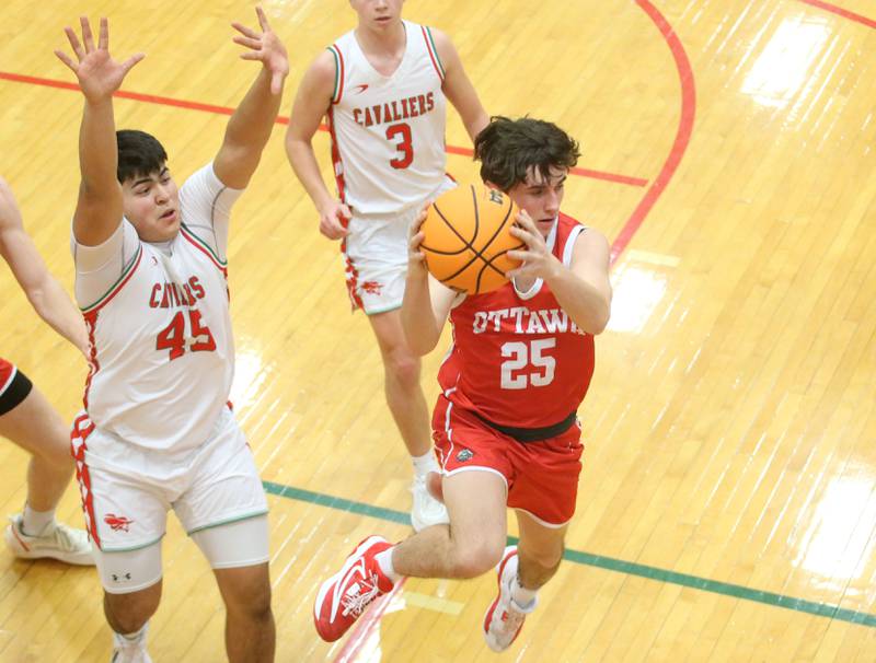 Ottawa's Lucas Farabaugh looks back to pass the ball off in mid air as L-P's Andy Medina guards the lane on Friday, Feb. 7, 2025 in Sellett Gymnasium at L-P High School.