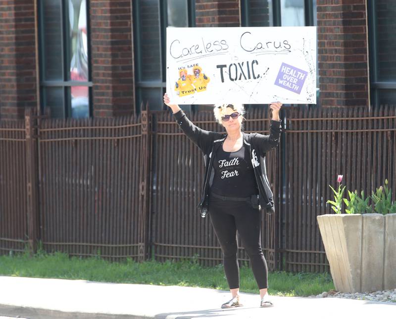 A protester holds a sign holds a sign that reads "Careless Carus toxic" while attending "Protest Carus Negligence" outside Carus headquarters across from the Westclox building on Friday, April 21, 2023 in Peru.