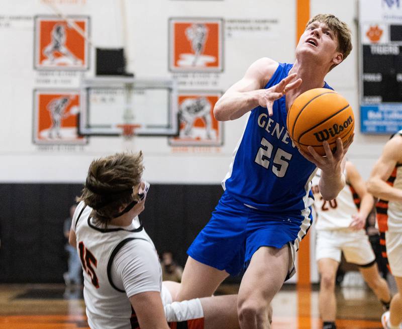 Geneva Hudson Kirby collides into Wheaton Warrenville South’s Hank Burlage while going up for a layup during a game at Wheaton Warrenville South High School on Tuesday, Dec. 3, 2024.