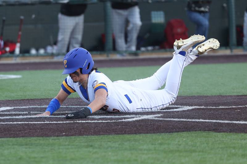 Joliet Central’s Jay Zepeda slides home uncontested against Aurora East on Monday, Mar. 11th in Joliet.
