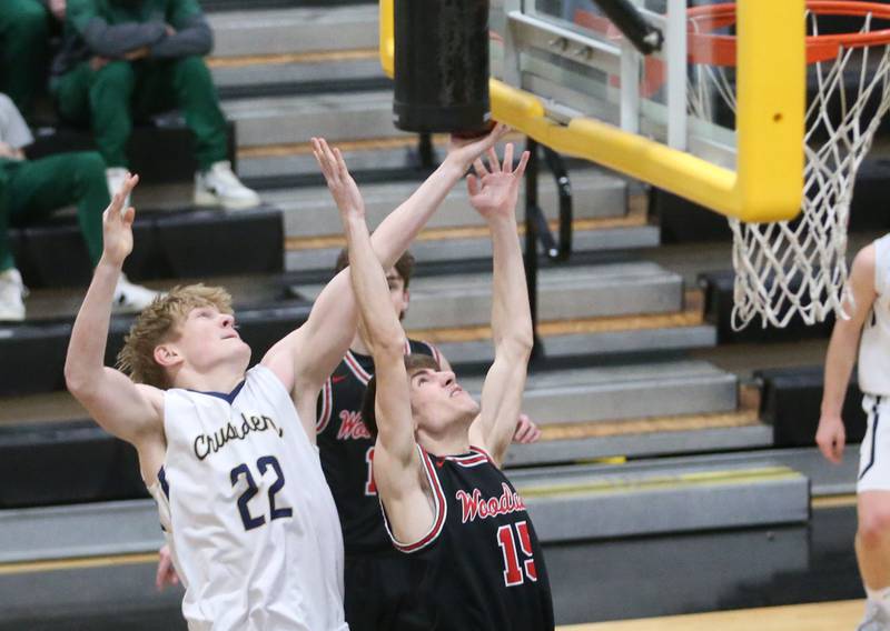 Marquette's Henry McGrath grabs a rebound over Woodland's Quentin Porter during the Tri-County Conference Tournament on Thursday, Jan. 25, 2024 at Putnam County High School.