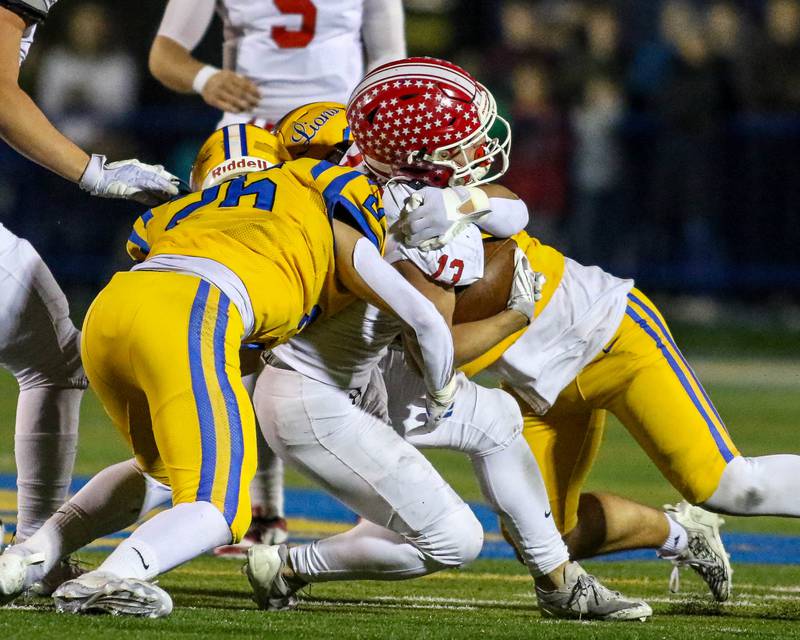 Lyon's Lou Ratcliffe (26) and Brady Rusk (87) combine on a tackle of Naperville Central's Aiden Clark (13) during Class 8A quarterfinal football game between Naperville Central at Lyons on Friday, Nov 15, 2024  in Western Springs.