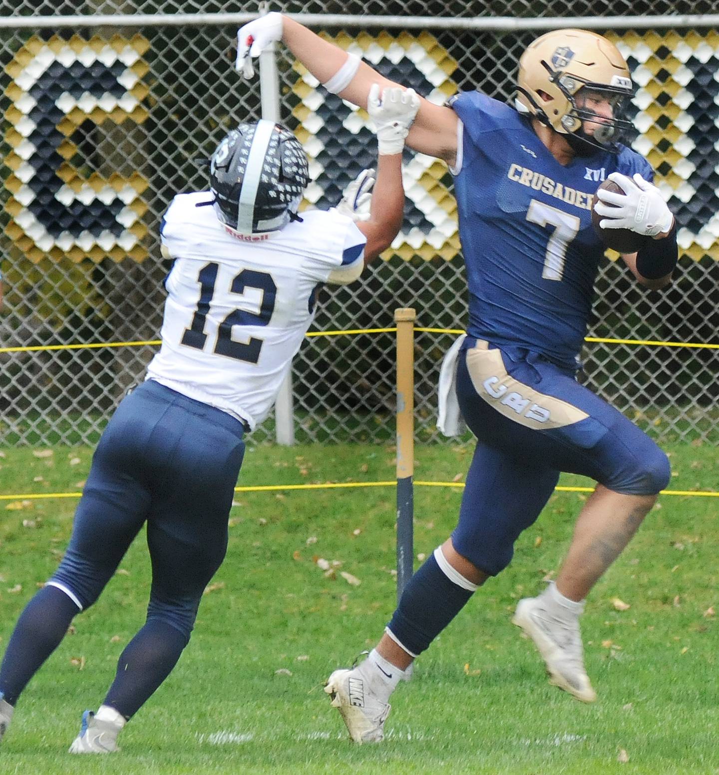 Marquette’s Blayden Cassel fends off Knoxville’s Tysean Pullens as heads toward the end zone during the 2nd quarter Saturday at Marquette.