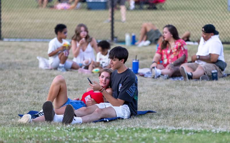 Danny Bremer, 16, and Megan Maertens, 17, wait for the start of the “July 4th Fireworks” at Langum Park in St. Charles on Friday, July 4, 2025.