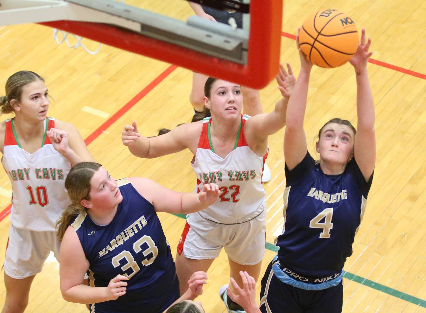 Marquette's Hunter Hopkins grabs a rebound over L-P's Brianna Ruppert as teammate Madison Kozolowski (33) defends off L-P's Kelsey Frederick on Saturday, Jan. 4, 2025 in Sellett Gymnasium at L-P High School.