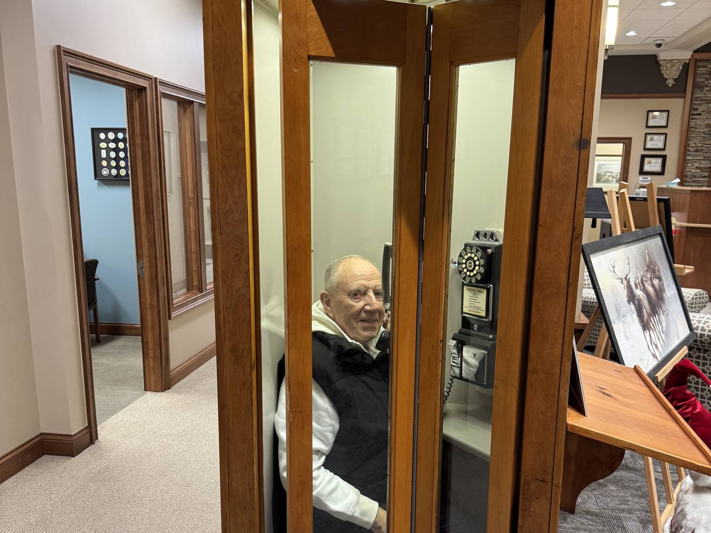 Operation St. Nick Founder Joe Schmitz inside a 1960s telephone booth, which will be up for auction on Sunday, Dec. 7, 2025. Photo taken on Tuesday, Nov. 25, 2025.
