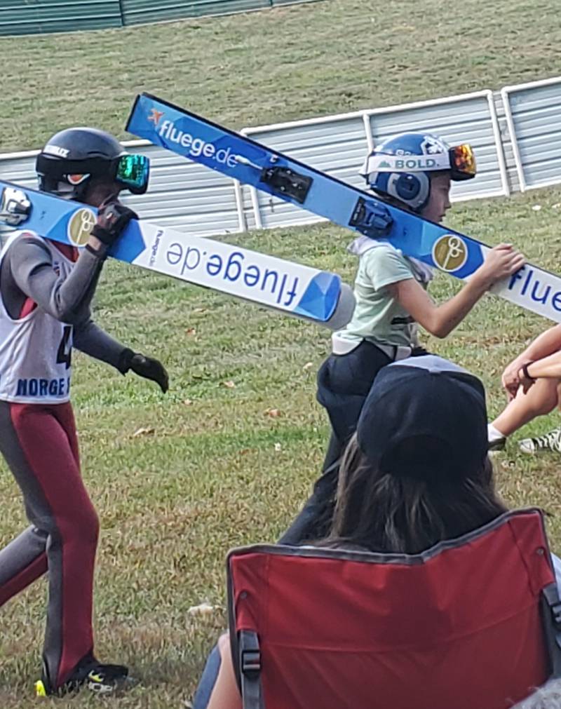 Skiers head to the shuttle tat brings them back to the 40-foot ski jump slope on Saturday, Oct. 4, 2025, at Fox River Grove Norge Ski Club. The annual Jumptoberfest brought ski jumpers from around the country, jumping in 80-degree weather.