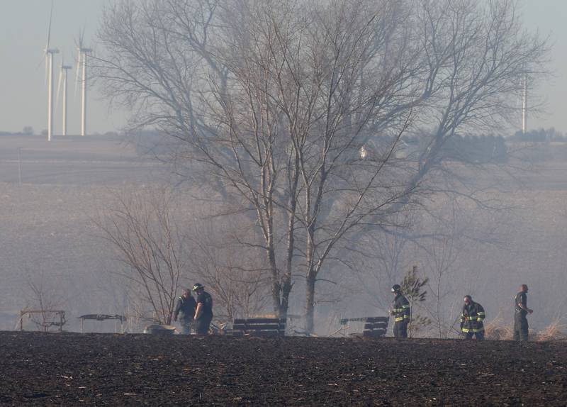 Firefighters walk the perimeter of a field in the 26000 block of 2500 East Street on Wednesday, Feb. 18, 2026 near Ohio. A Mutual Aid Box Alarm call was elevated to the second-alarm for the brush fire. Bureau County Fire departments from Princeton, Ohio, Malden and others assisted with the fire.