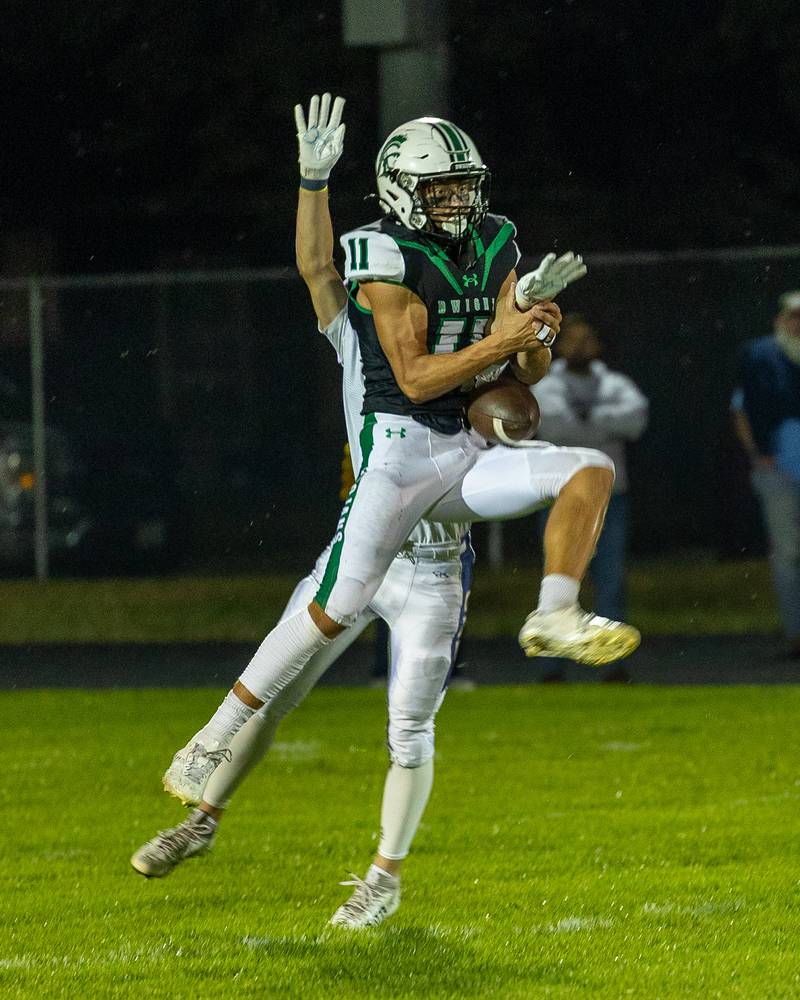 Joey Starks (11) of Dwight juggles ball in catch attempt as Easton Debernardi (9) of Marquette attempts to tackle on Friday, Sept. 19, 2025 at Dwight High School in Dwight.