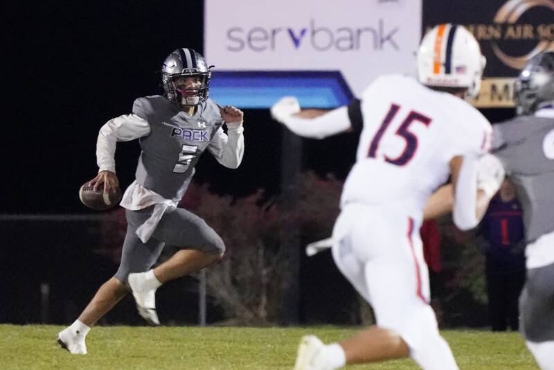 Oswego East's Niko Villacci (5) looks downfield during a football game against Oswego at Oswego East High School on Friday, October 25, 2024.