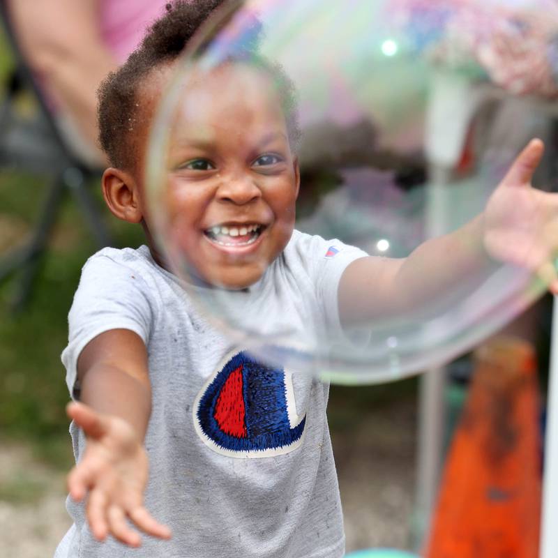 Kennedi Washington, 3, from Sycamore, plays with bubbles at one of the booths during the Juneteenth Community Celebration Saturday, June 15, 2024, at Hopkins Park in DeKalb.
