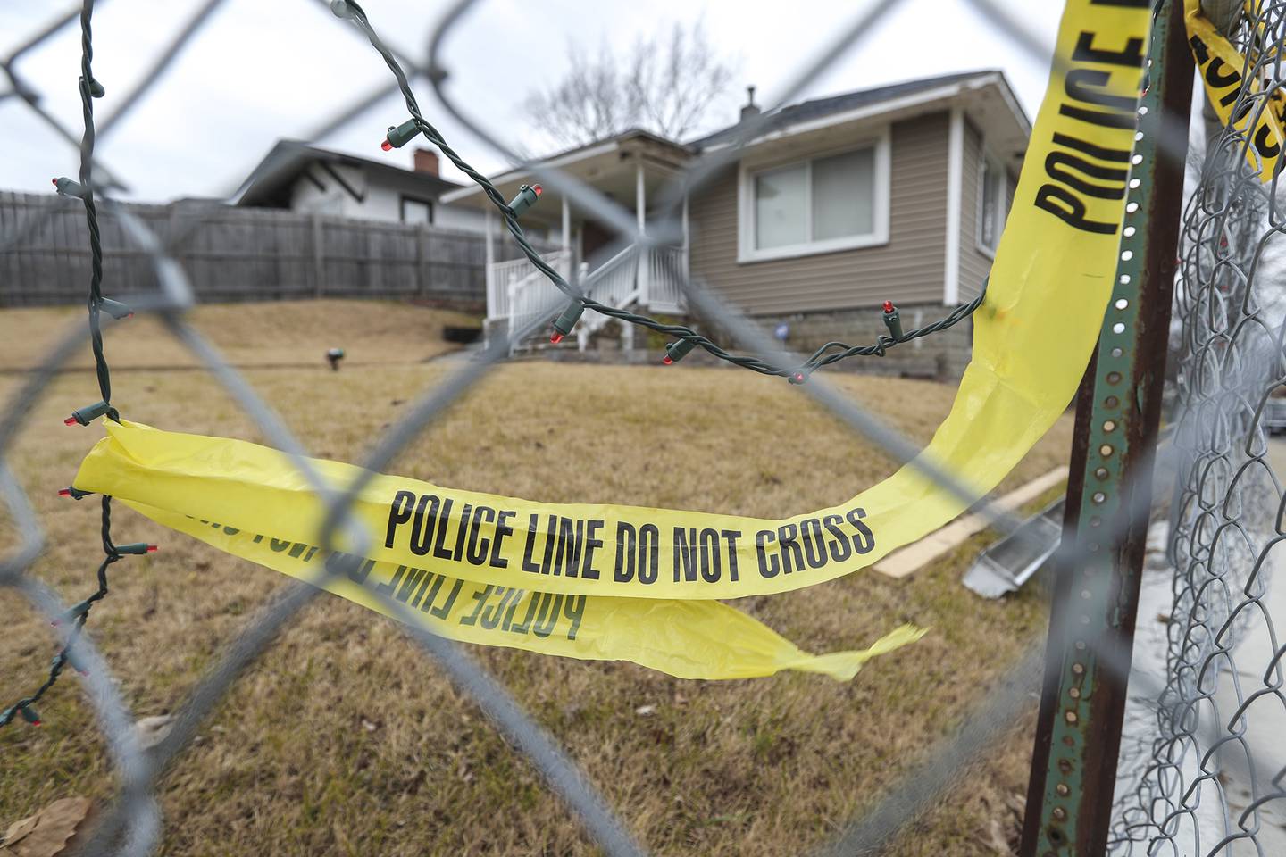Leftover police tape and Christmas lights intertwine on the fence of a home near a police officer involved shooting on Tuesday, Dec. 23, 2020, on the 800-block of Second Avenue in Joliet, Ill. According to Will/Grundy Major Crimes Task Force, on Monday evening officers responded to a 911 call of a man threatening to shoot bystanders. The man threatened officers and after a standoff, police fired shots, killing the man.
