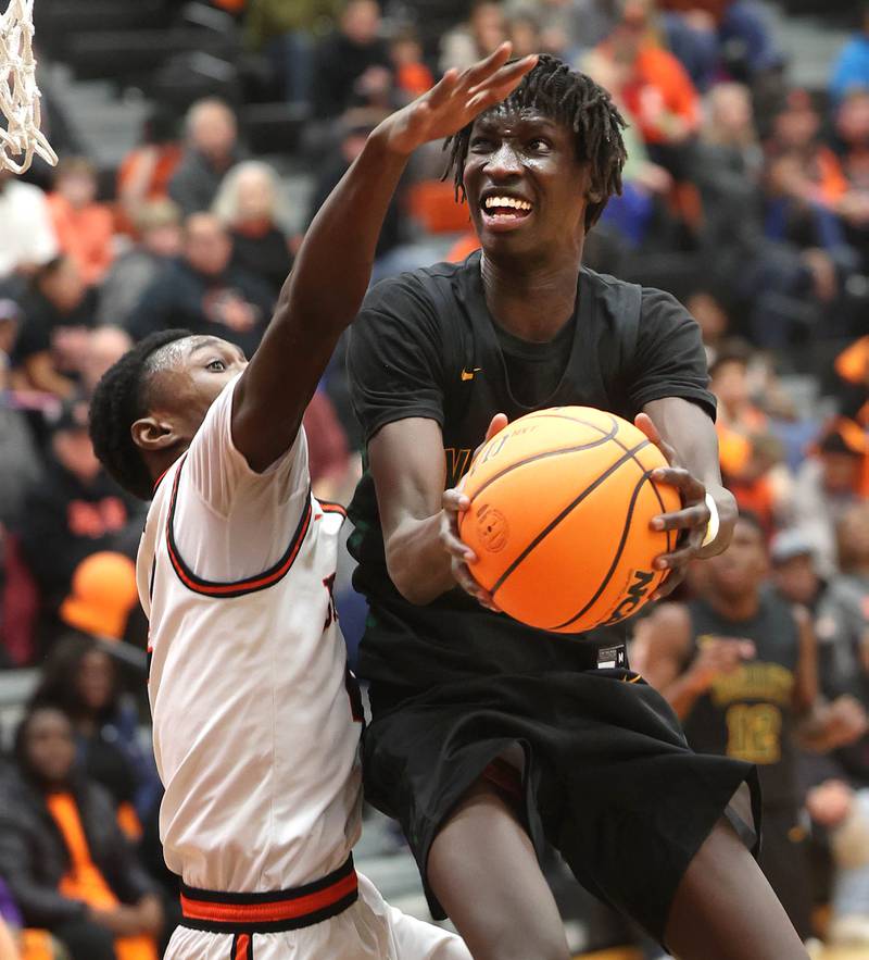 Waubonsie Valley's Moses Wilson goes to the basket against DeKalb's Marquise Bolden during their game Friday, Feb. 21, 2025, at DeKalb High School.