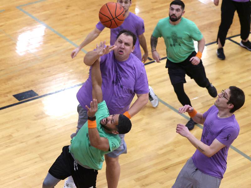 Fire/Police team member Ray Hernandez tries to shoot over Sycamore School Staff team member Nate Wright Thursday, Dec. 19, 2024, during the Heroes on Hardwood basketball game at Sycamore High School. The basketball game, which is a fundraiser for the Spartan Food Pantry, pits a team of Sycamore first responders against a squad of Sycamore School District 427 staff.