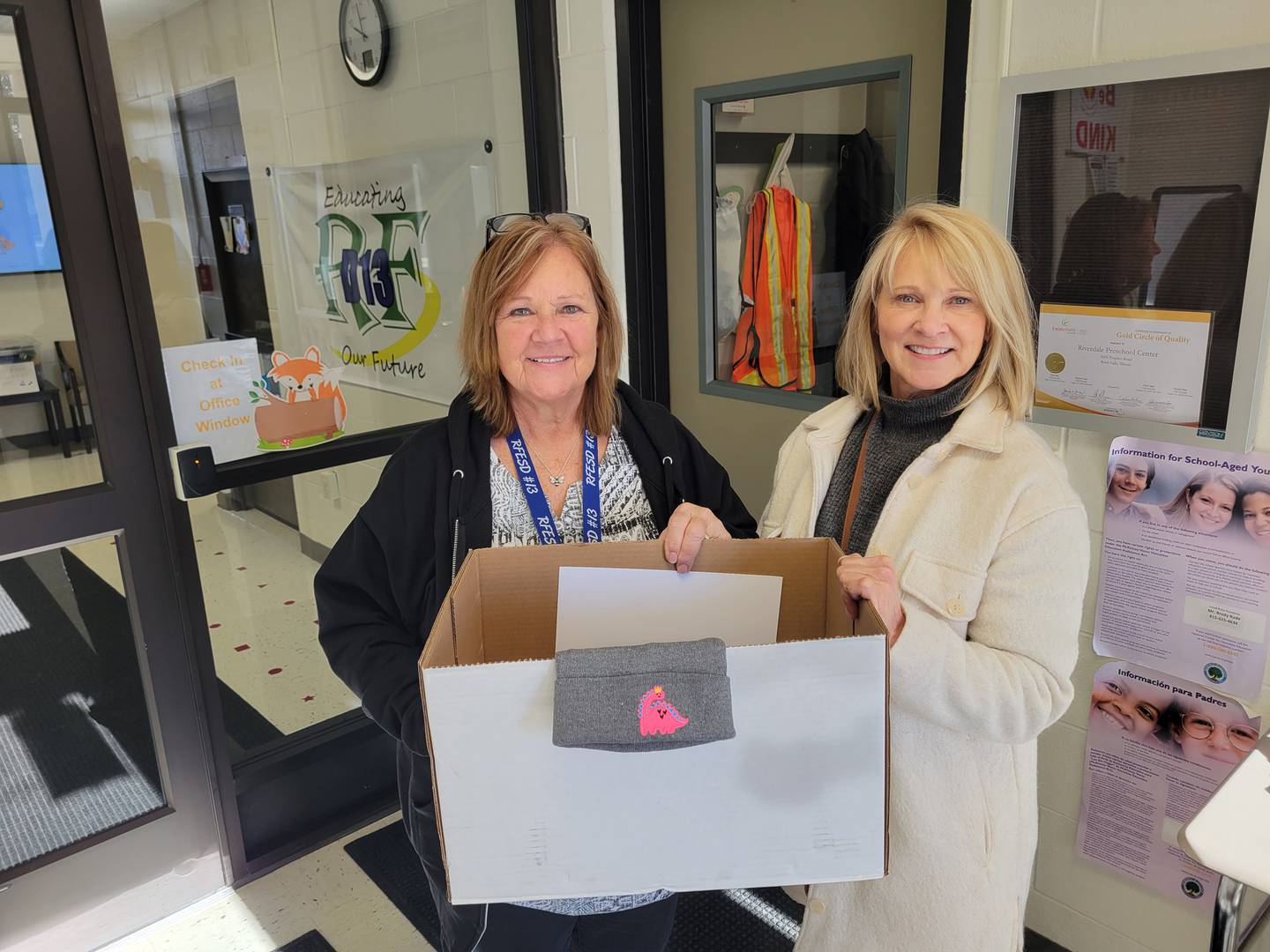 Barb Biba, left, secretary at Riverdale Preschool of Rock Falls Elementary District 13, accepts the donation of hats and mittens from Darla Ewing of the Rock Falls Rotary's community service committee. The group collected warm weather gear and then donated it to all the elementary schools in the Rock Falls area. The Rotary says children often lose these items and need replacements.