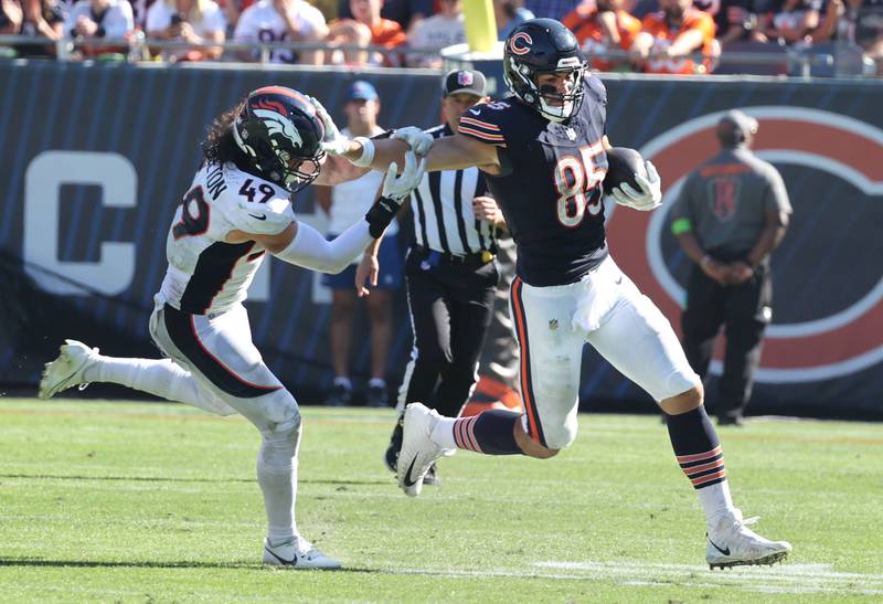 Chicago Bears tight end Cole Kmet fends off Denver Broncos linebacker Alex Singleton during their game Sunday, Oct. 1, 2023, at Soldier Field in Chicago.
