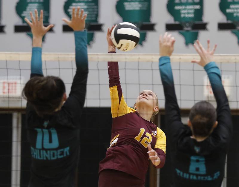Richmond-Burton's Zoe Freund tries to hit the ball through the block of Woodstock North's Ava Kardaras (left) and Woodstock North's Avari Howard (right) during a Kishwaukee River Conference volleyball match on Monday, Sept. 15, 2025, at the Woodstock North High School.