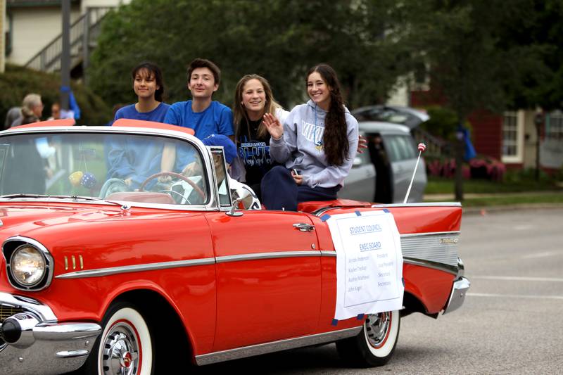 (Right to left) Audrey Mathews, John Kegel, Kaylee Tredup and Jordan Anderson, the Geneva High School Executive Board, ride in a convertible during the school’s homecoming parade on State Street on Friday, Sept. 23, 2022.