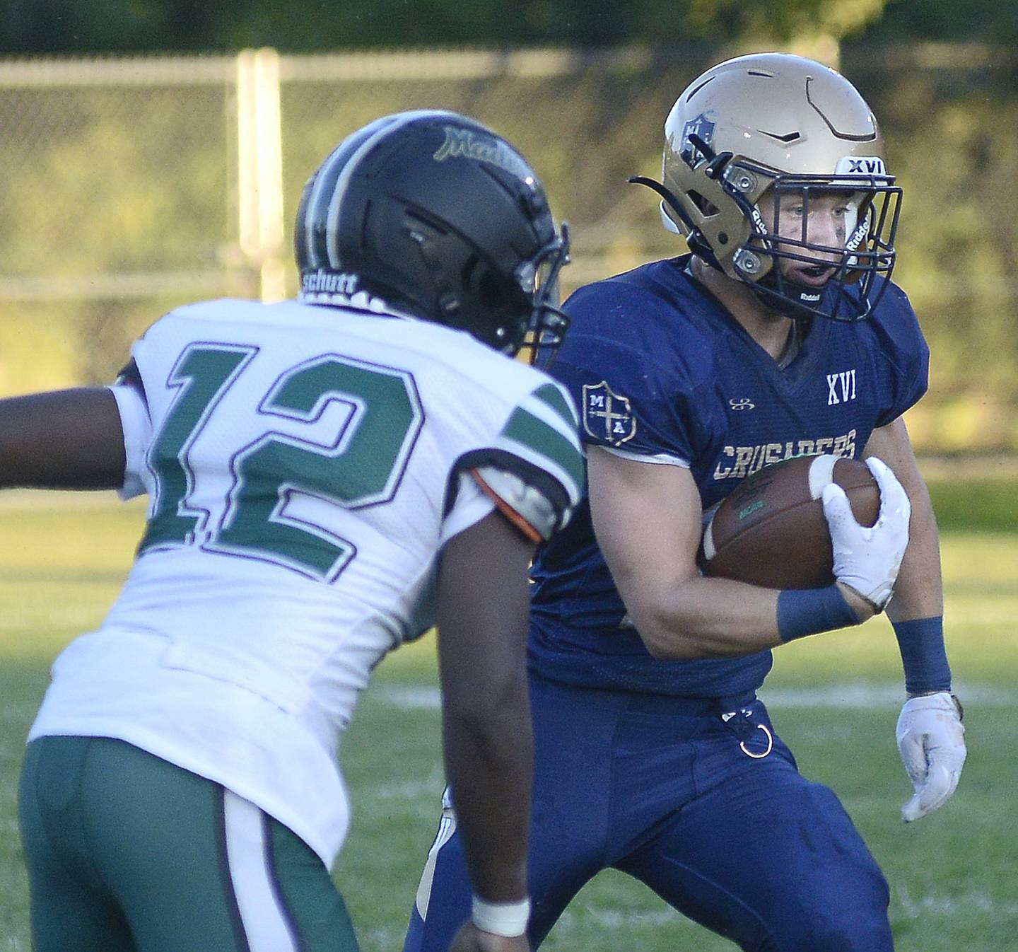 Marquette’s Pete McGrath races past Madison’s Jalen Belford on a run Friday at Gould Stadium in Ottawa.