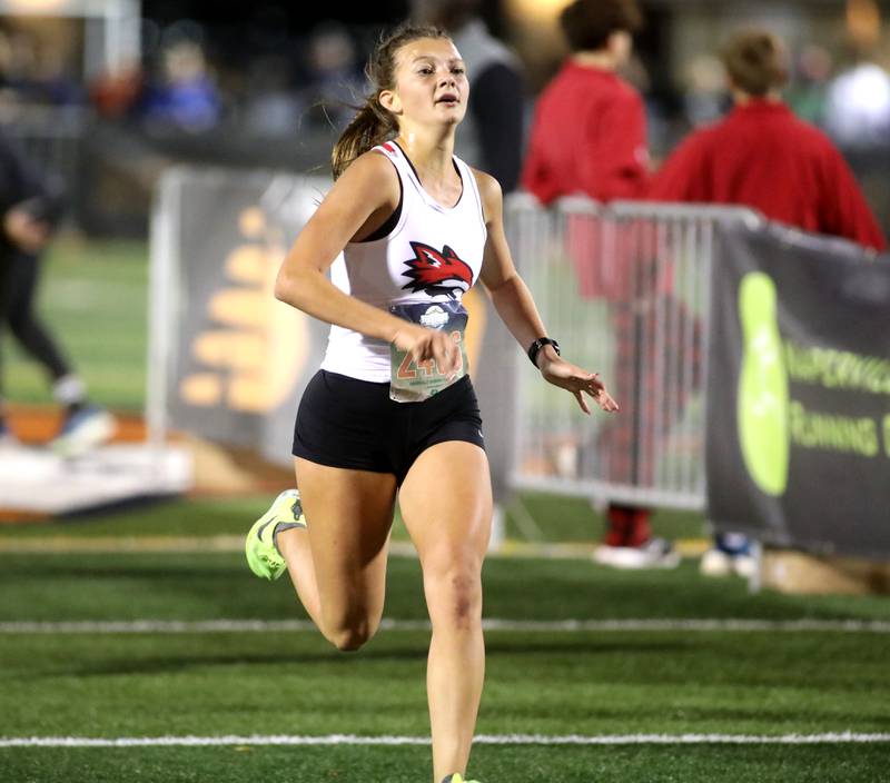 Yorkville’s Ashley Schraeder runs to the finish in the varsity girls race during the Naperville North Twilight Cross Country Invitational on Wednesday, Oct. 9, 2024 in Naperville.