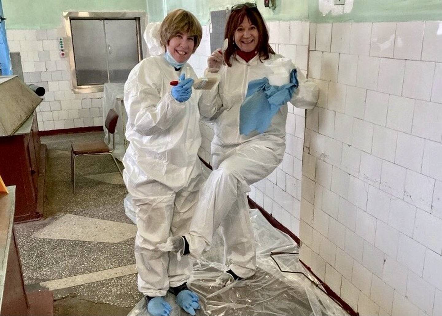 Rene Koehler (right) and Tori Lee (left) painting walls of their refugee camp in an abandoned Soviet hospital. (photo provided)