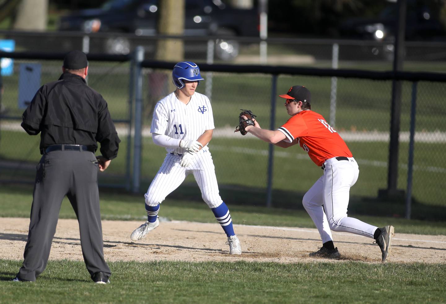 Geneva’s Joe Cosentino is tagged out by Wheaton Warrenville South’s Jacob Conover after getting caught in a pickle between first and second base during a game at Geneva on Monday, April 8, 2024.