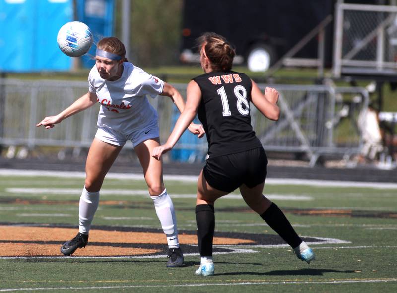 St. Charles East's Sophia Wollenberg heads the ball away from Wheaton Warrenville South's Kayla Waterman during a game on Friday, May 16, 2025 in Wheaton.