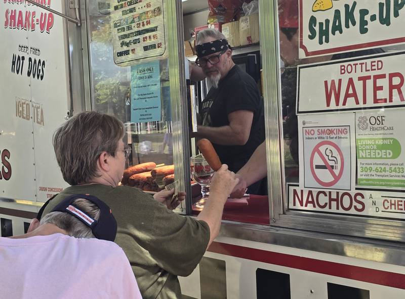 A patron is handed a corn dog Saturday, Sept. 14, 2024, from Streator's own Cruisin Concessions during the Fall Food Truck Festival at City Park