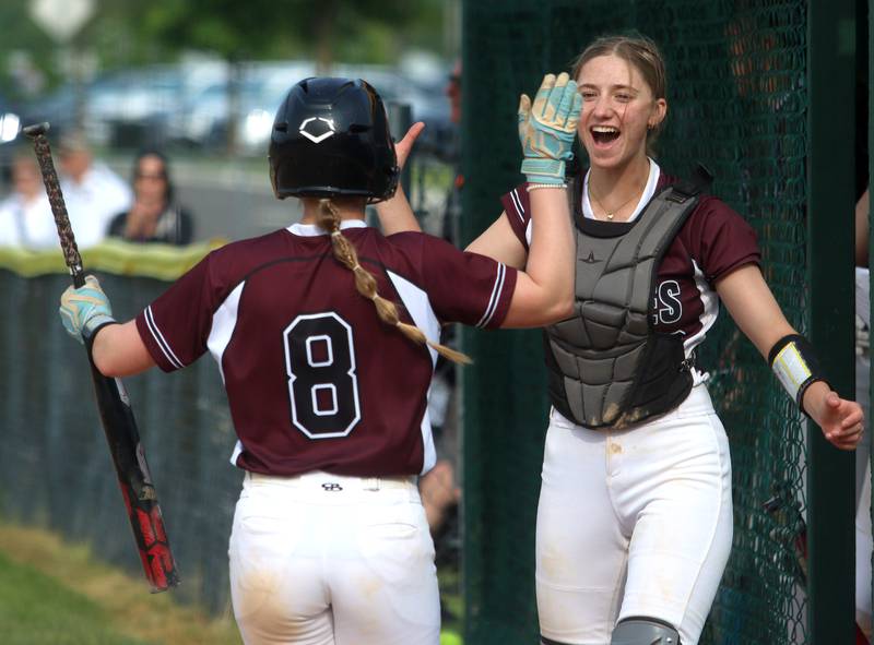 Prairie Ridge’s Kendra Carroll, right, greets Adysen Kiddy after Kiddy scored against Crystal Lake Central in Class 3A Regional softball action at Crystal Lake South Wednesday.