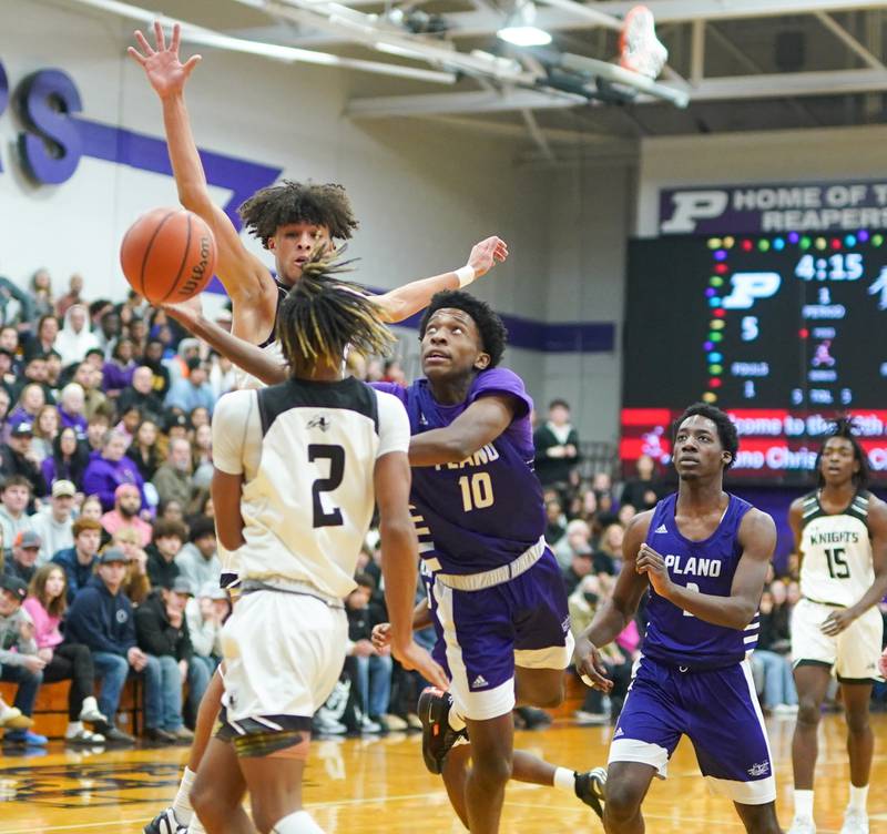 Plano's Davione Stamps (10) drives to the hoop against Kaneland's Evan Frieders (3) and Isaiah Gipson (2) during a championship game of the 60th annual Plano Christmas Classic Basketball Tournament at Plano High School on Saturday, Dec 30, 2023.
