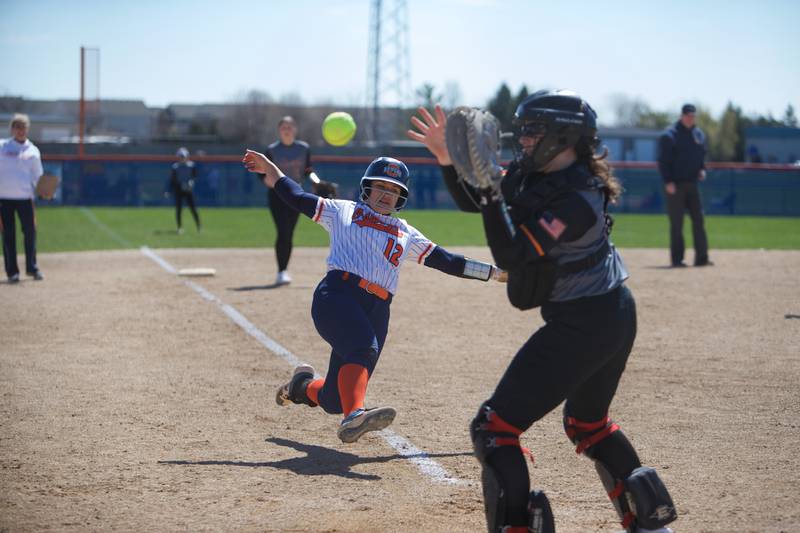 Warrenville South's Mallorie Durian awaits the ball as Oswego's Aubriella Garza slides into home on Saturday, April 6, 2024 in Oswego.