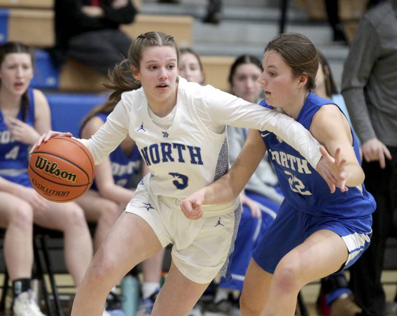 St. Charles North’s Alyssa Hughes (left) drives toward the basket past Wheaton North’s Mira Spillane during the Class 4A St. Charles North Regional final on Thursday, Feb. 16, 2023.