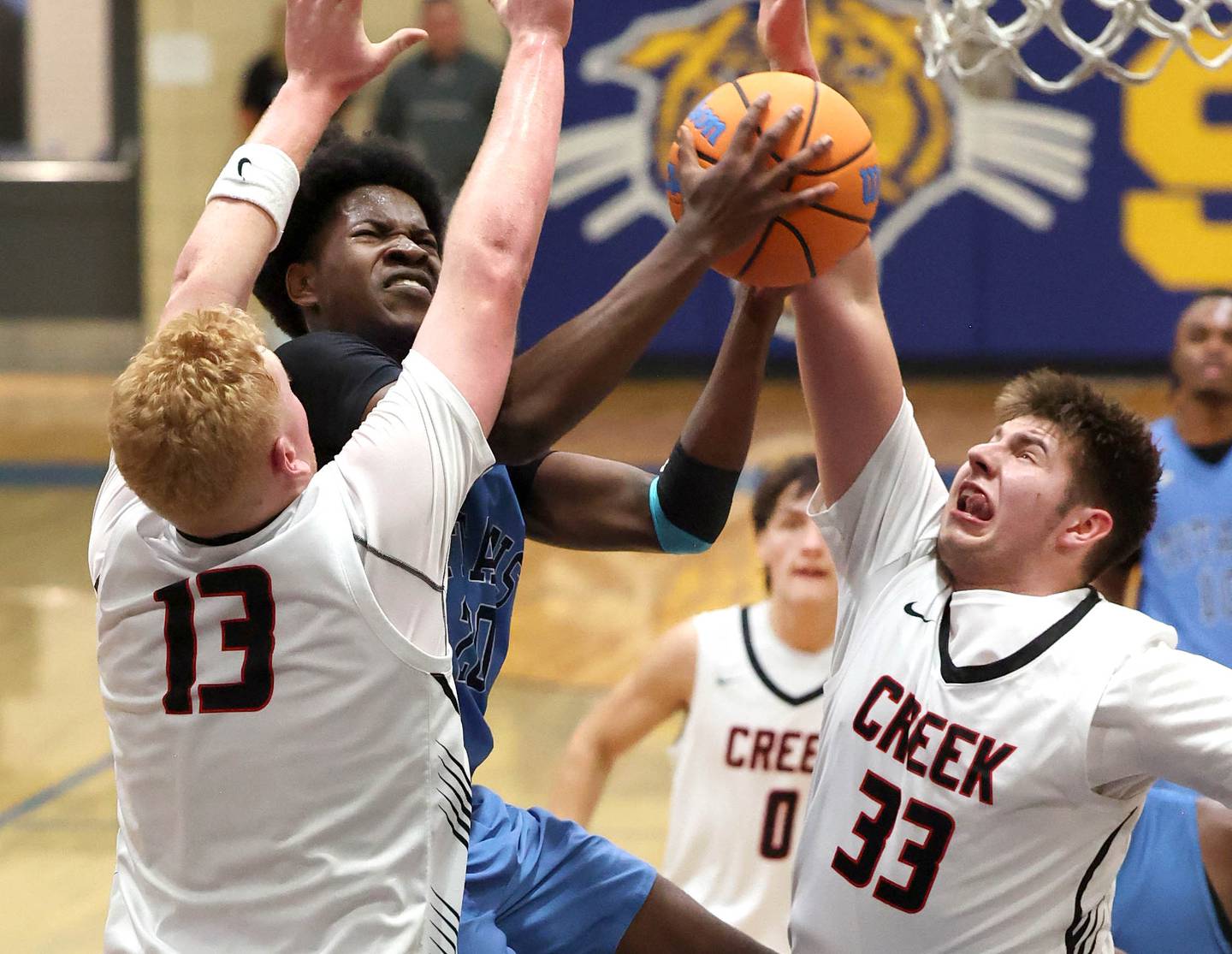 IMSA’s Mofe Suleiman goes to the basket against Indian Creek's Isaac Willis (left) and Payton Hueber Friday, Feb. 6, 2026, during their Little 10 Conference championship game at Somonauk High School.