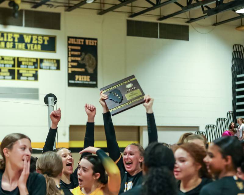 Joliet West celebrates with the regional final plaque afer defeating Bolingbrook in straight sets  Oct 26, 2023.