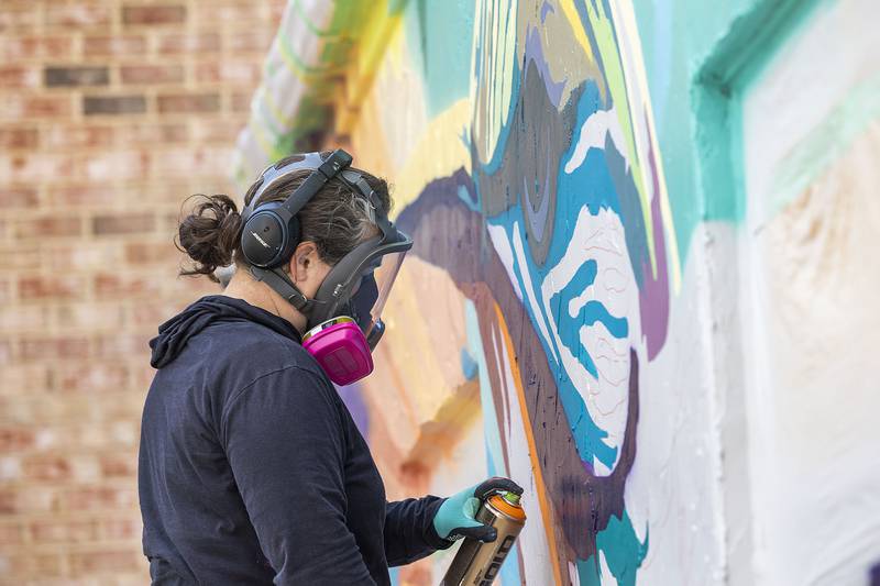 Dixon based muralist Anne Hermes works on a piece Saturday, Nov. 1, 2025, on the Blackhawk Hills Regional Council building in Rock Falls. The hummingbird design was chosen to reflect the council’s motivation towards nature conservancy and to appeal to a large audience.