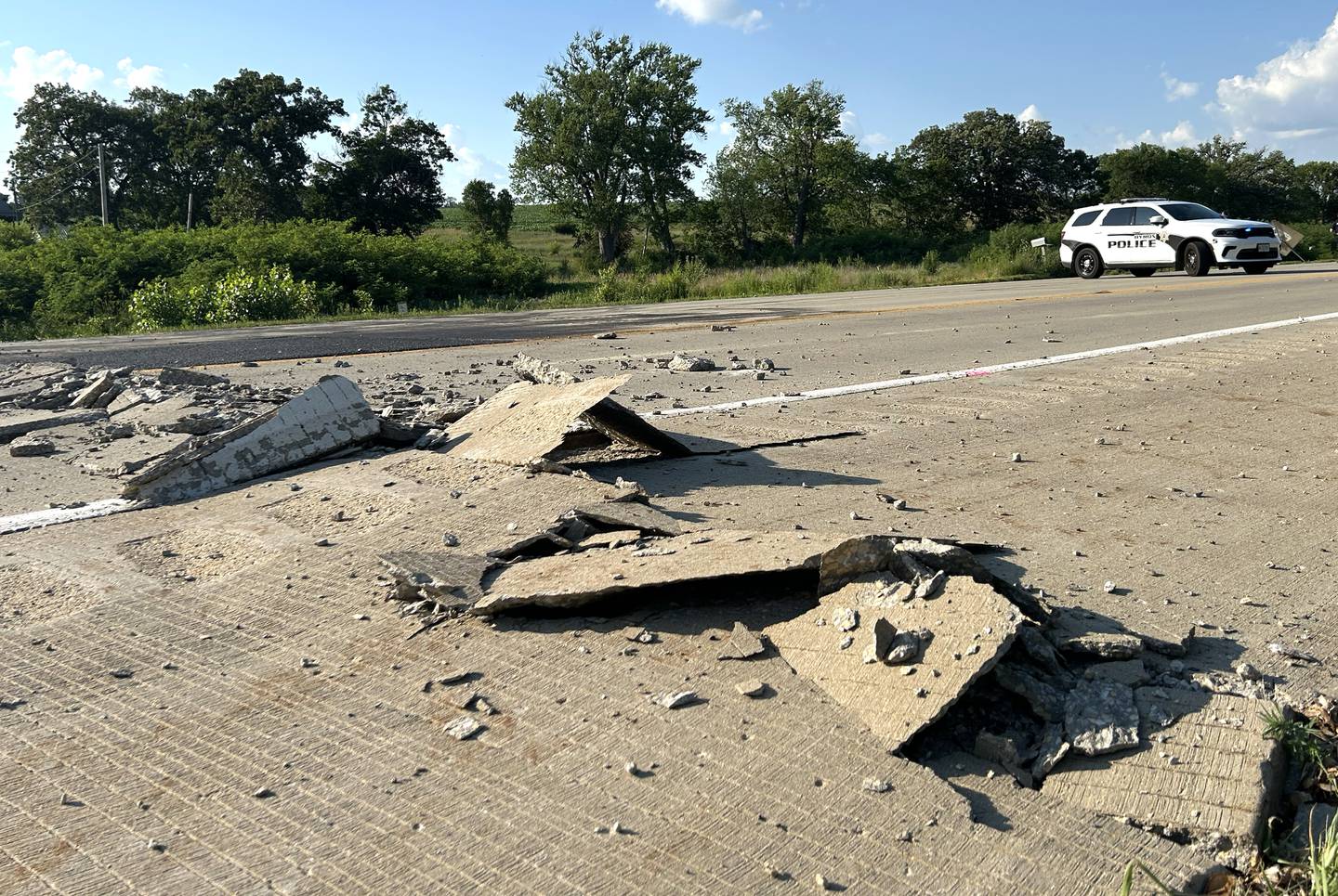 A Byron squad car blocks traffic on Illinois Route 2 on Wednesday evening, July 2, 2025 after the pavement buckled just north of the intersection with Town Hall Road, south of Byron.