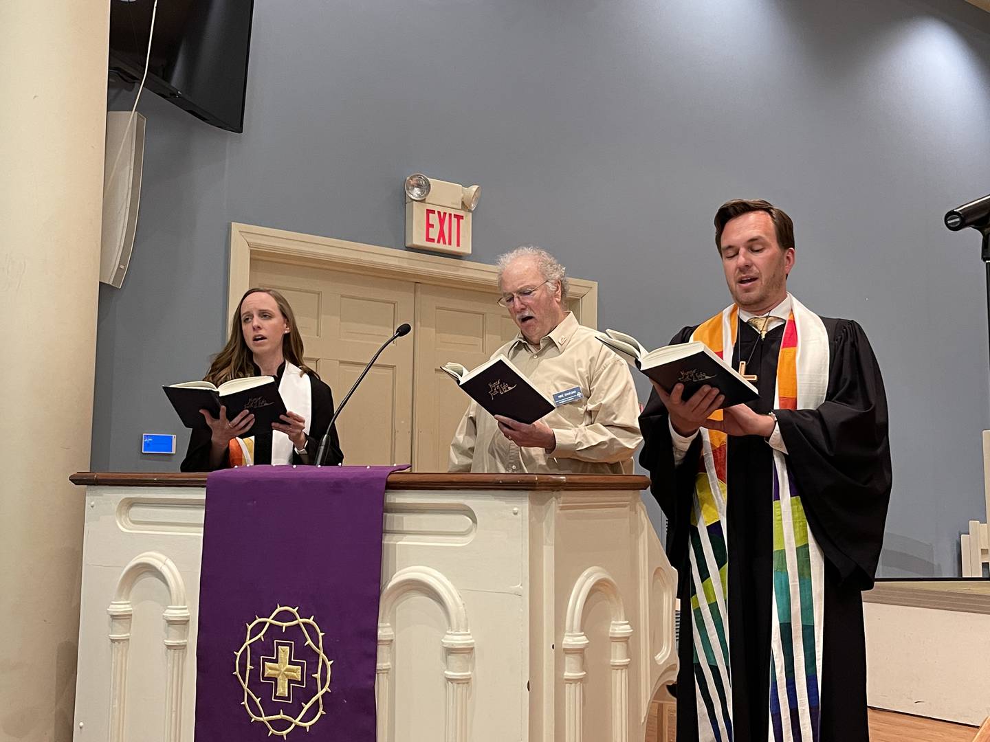 From left to right, Associate Pastor Emily Davis, Mike Chakoian and Senior Pastor Eric Fistler lead a hymn Sunday, April 3, 2022, at the First Congregational Church in Crystal Lake. The hymn was part of a ceremony at the church, orchestrated among several churches in the area, to show solidarity with those in Ukraine.