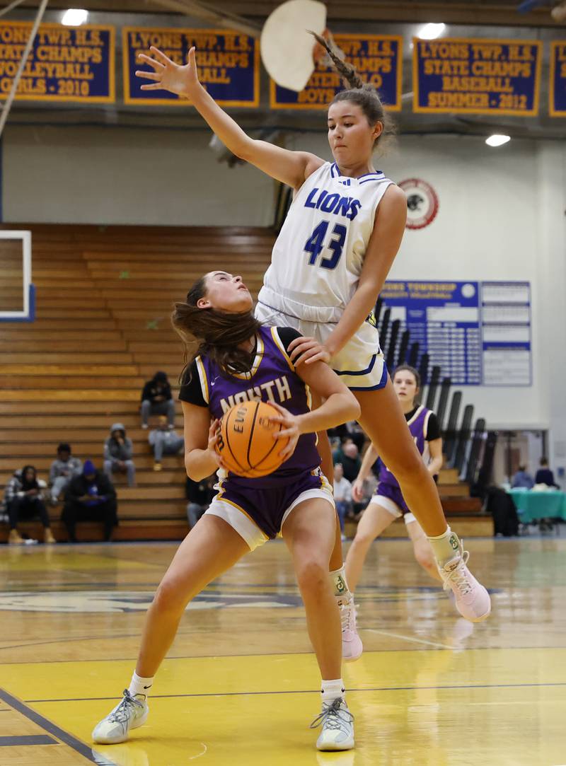 Downers Grove North's Adysen Fanta (15) tries to take a shot as Lyons' Emma O'Brien (43) goes airborne to defend during the girls varsity basketball game between Downers Grove North and Lyons Township on Saturday, Jan. 11, 2025 in La Grange.