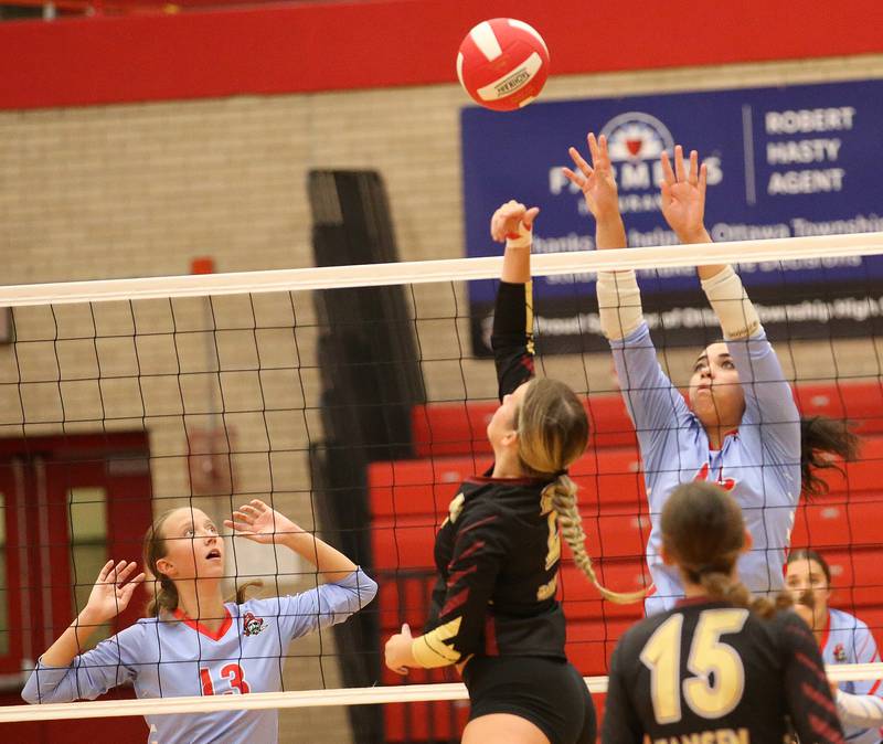 Morris's Ayla Phillips gets the ball over to the Ottawa side of the net as Ottawa's Ayla Dorsey and Chey Joachim prepare to defend on Tuesday, Sept. 12, 2023 in Kingman Gym at Ottawa High School.