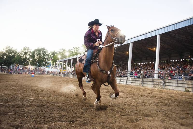 Courtney Engle heads for the finish line in the barrel racing event Tuesday, August 16, 2022 during the Next Level Bull Riding tour at the Whiteside County fair. Engle took the win posting the fastest time clearing all three barrels.