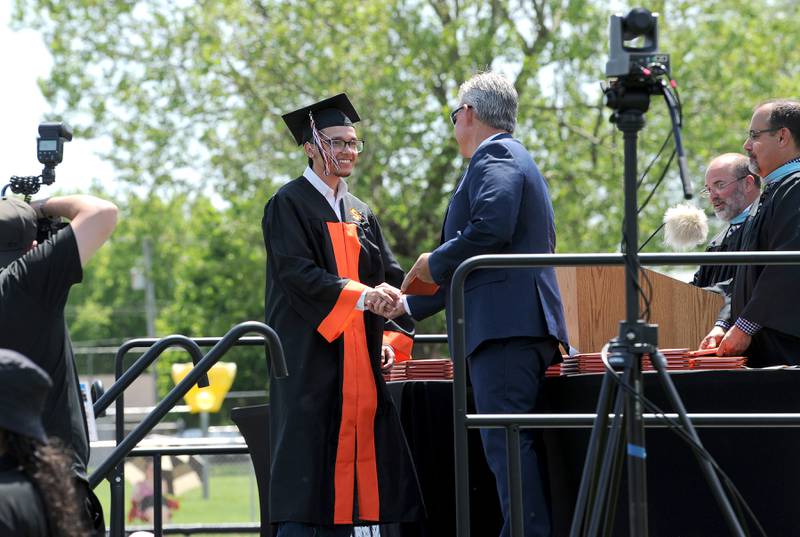 Ricardo Ayala receives his diploma during Sandwich High School's graduation ceremony on the football field, Sunday, May 19, 2024.